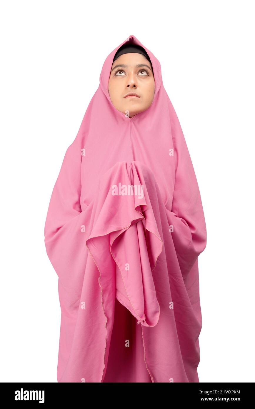 Asian Muslim woman in a veil standing while raised hands and praying ...