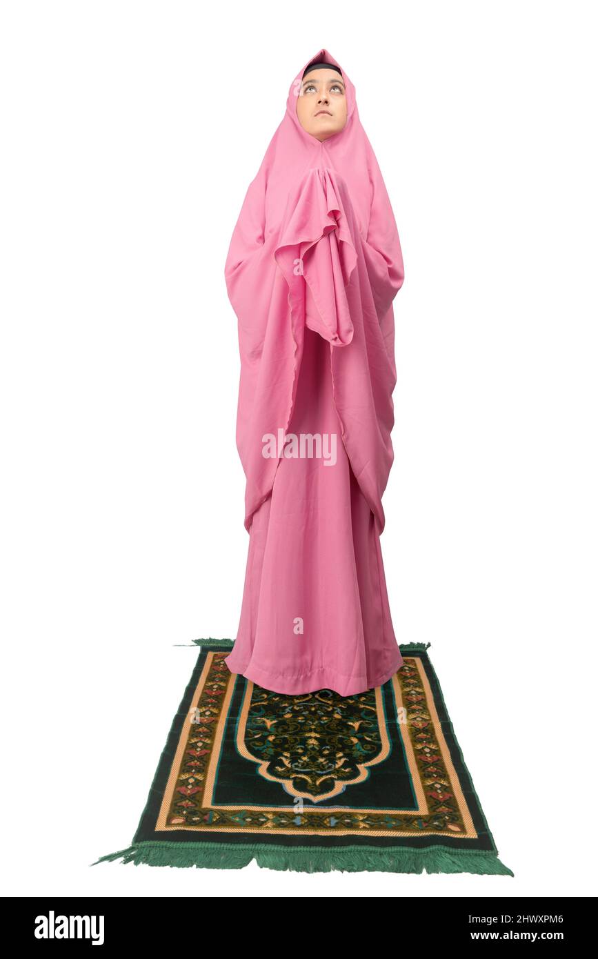 Asian Muslim woman in a veil standing while raised hands and praying ...