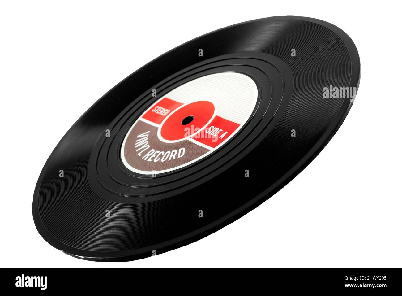 Obsolete sound recording technology, retro analogue medium and nostalgia concept with a tilted vinyl record isolated on white background leaning on it Stock Photo