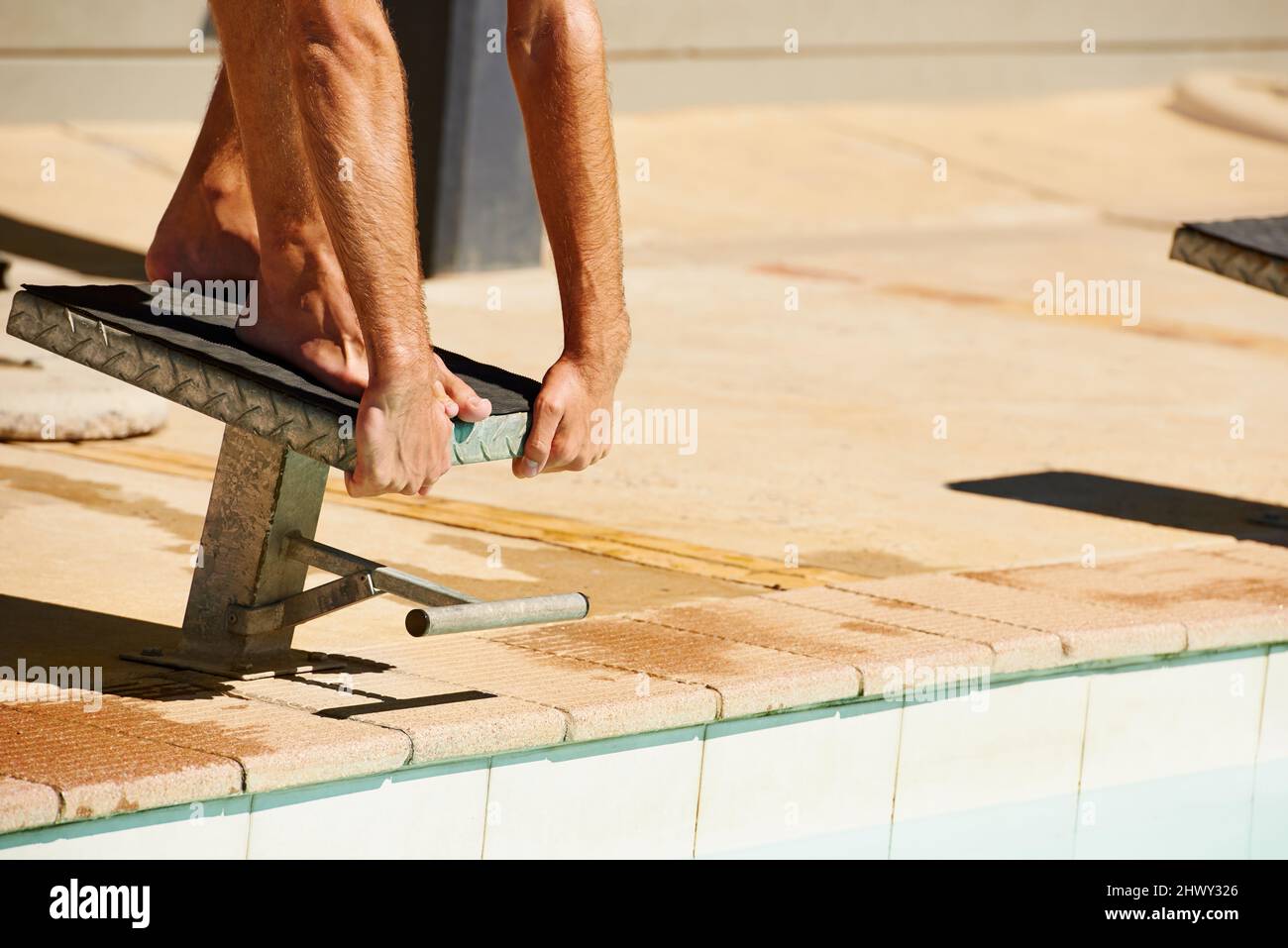 Starting the race. A young man diving off a starting block Stock Photo