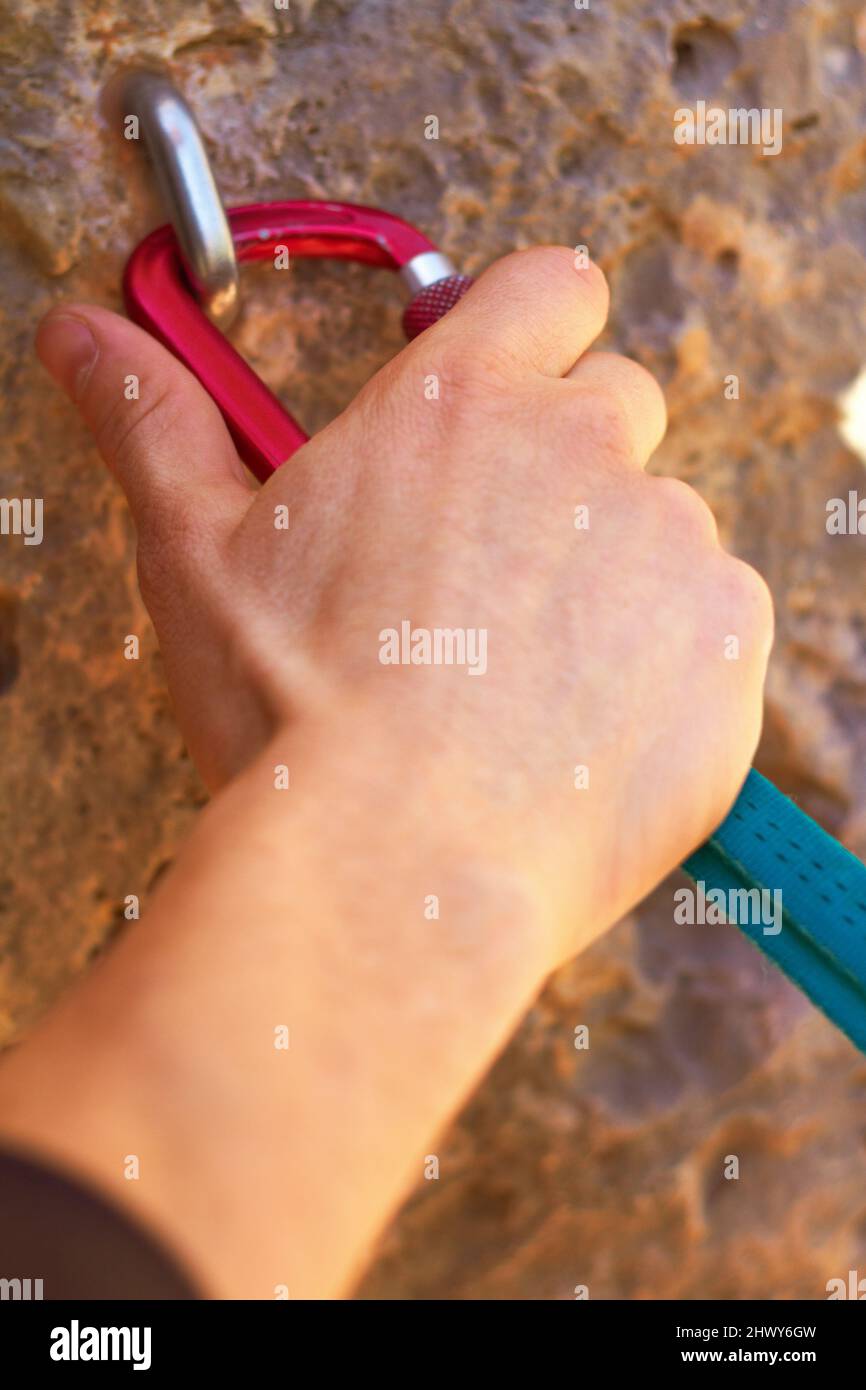 Getting a stable grip. Closeup of a climbers hands clipping a quickdraw