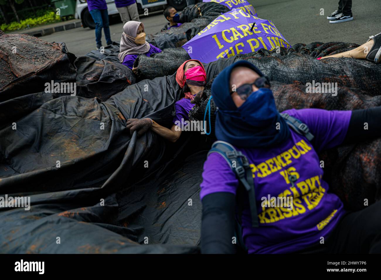Jakarta, Indonesia. 08th Mar, 2022. Activists seen laying on a sculpture depicting an oligarchy-themed octopus during the protest on International Women's Day.Women activists rally on International Woman's Day in the Monas area, Jakarta. The mass demand the government to implement a social protection system that does not discriminate against women. Credit: SOPA Images Limited/Alamy Live News Stock Photo