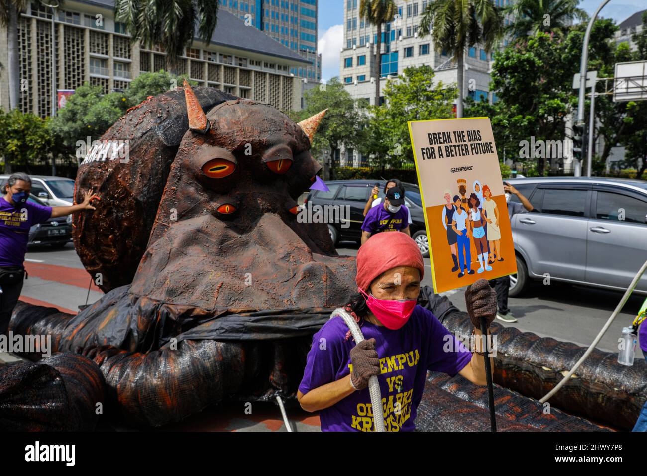 Jakarta, Indonesia. 08th Mar, 2022. An activist holds a placard while pulling a sculpture depicting an oligarchy-themed octopus during the protest on International Women's Day.Women activists rally on International Women's Day in the Monas area, Jakarta. The mass demand the government to implement a social protection system that does not discriminate against women. Credit: SOPA Images Limited/Alamy Live News Stock Photo