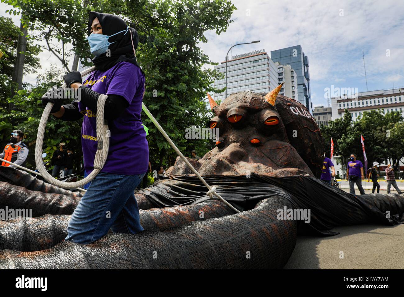 Jakarta, Indonesia. 08th Mar, 2022. An activist seen pulling a sculpture depicting an oligarchy-themed octopus during the protest on International Women's Day.Women activists rally on International Women's Day in the Monas area, Jakarta. The mass demand the government to implement a social protection system that does not discriminate against women. Credit: SOPA Images Limited/Alamy Live News Stock Photo