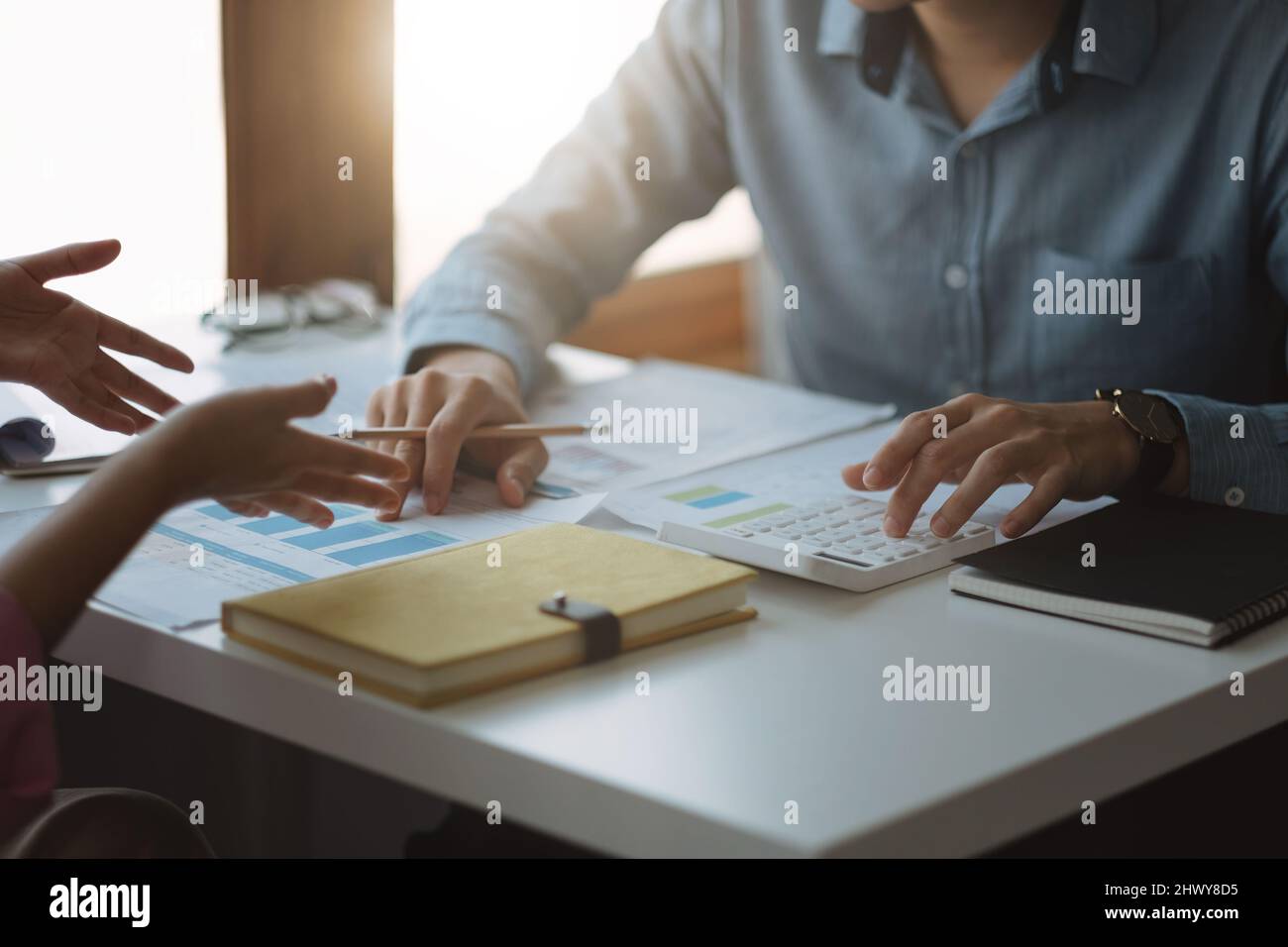 Two business people talking about graph and analysis about finance budget company and using calculator in office room Stock Photo