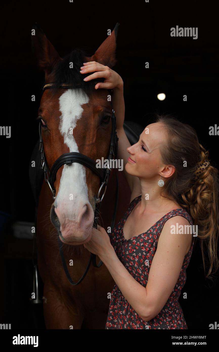 Portrait of young country girl and horse in stable Stock Photo
