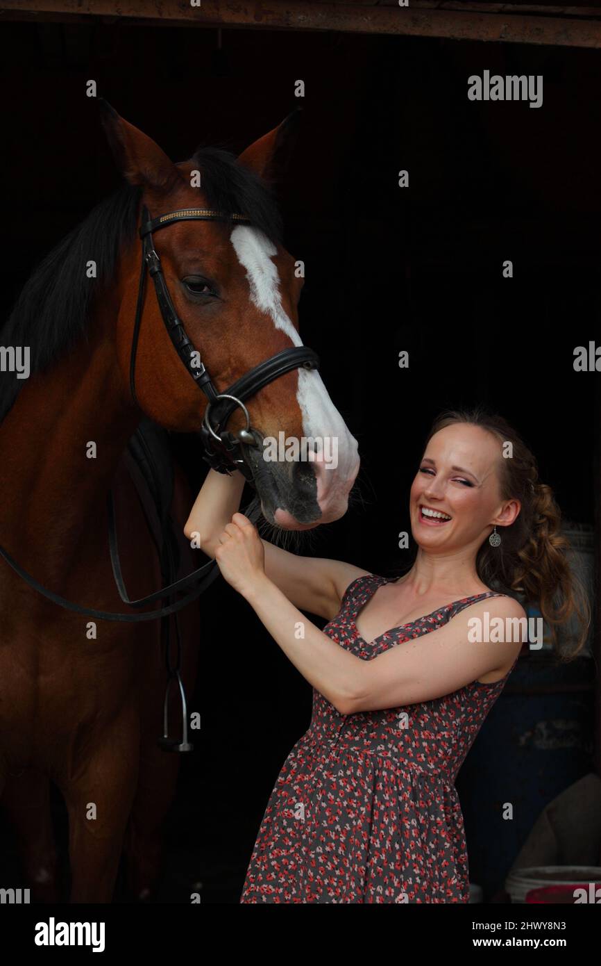 Portrait of young country girl and horse in stable Stock Photo