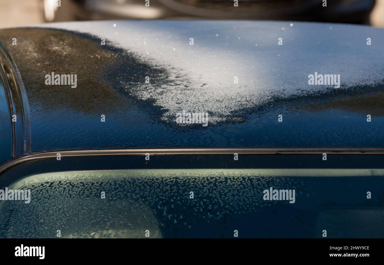 frozen roof of a car in the sun, defrosting & melting in the sun Stock