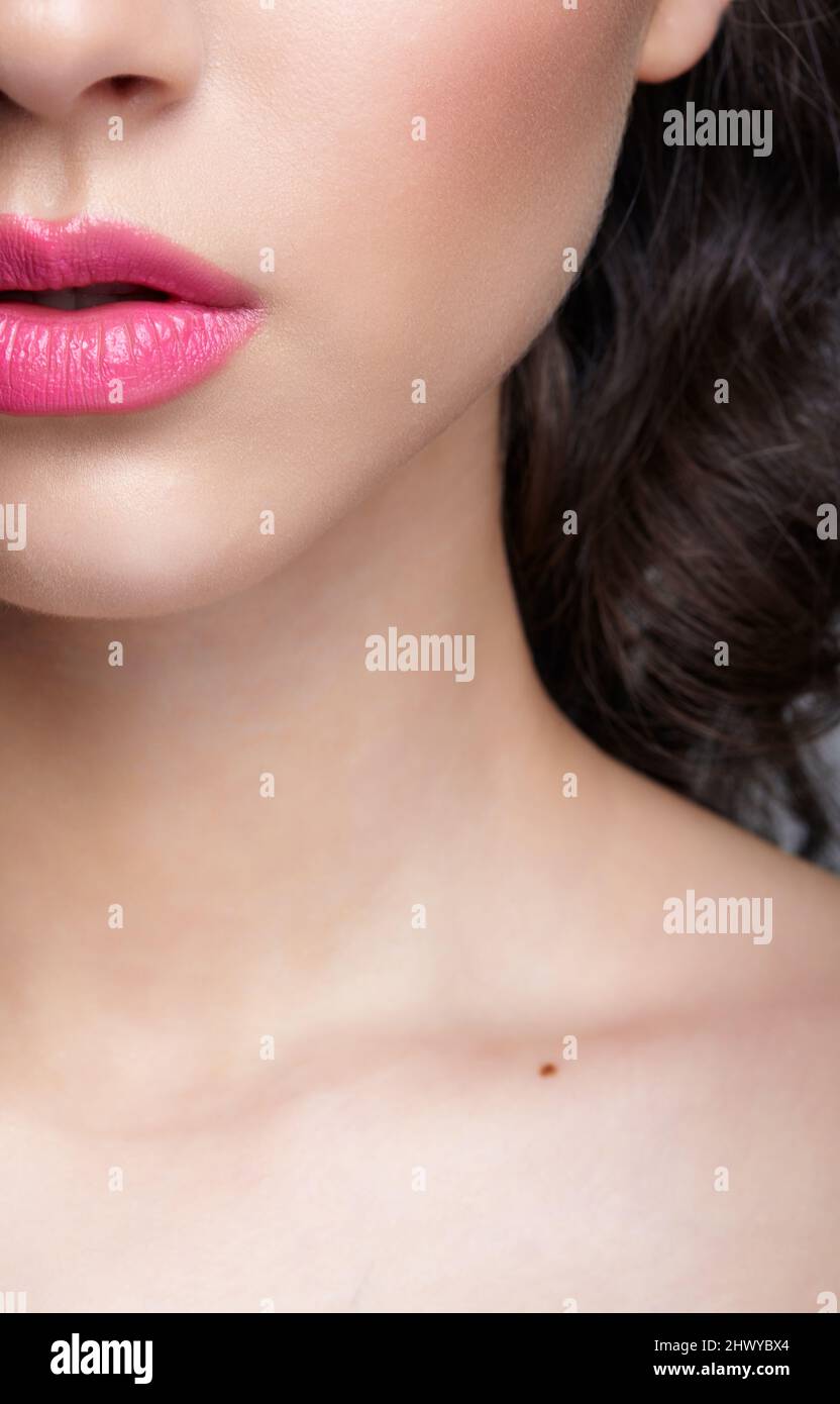 Closeup macro shot of human female face. Woman with pink lips beauty makeup. Stock Photo