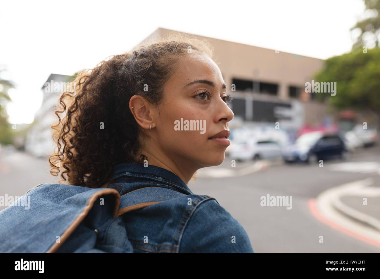 Young african american woman looking over shoulder in city Stock Photo