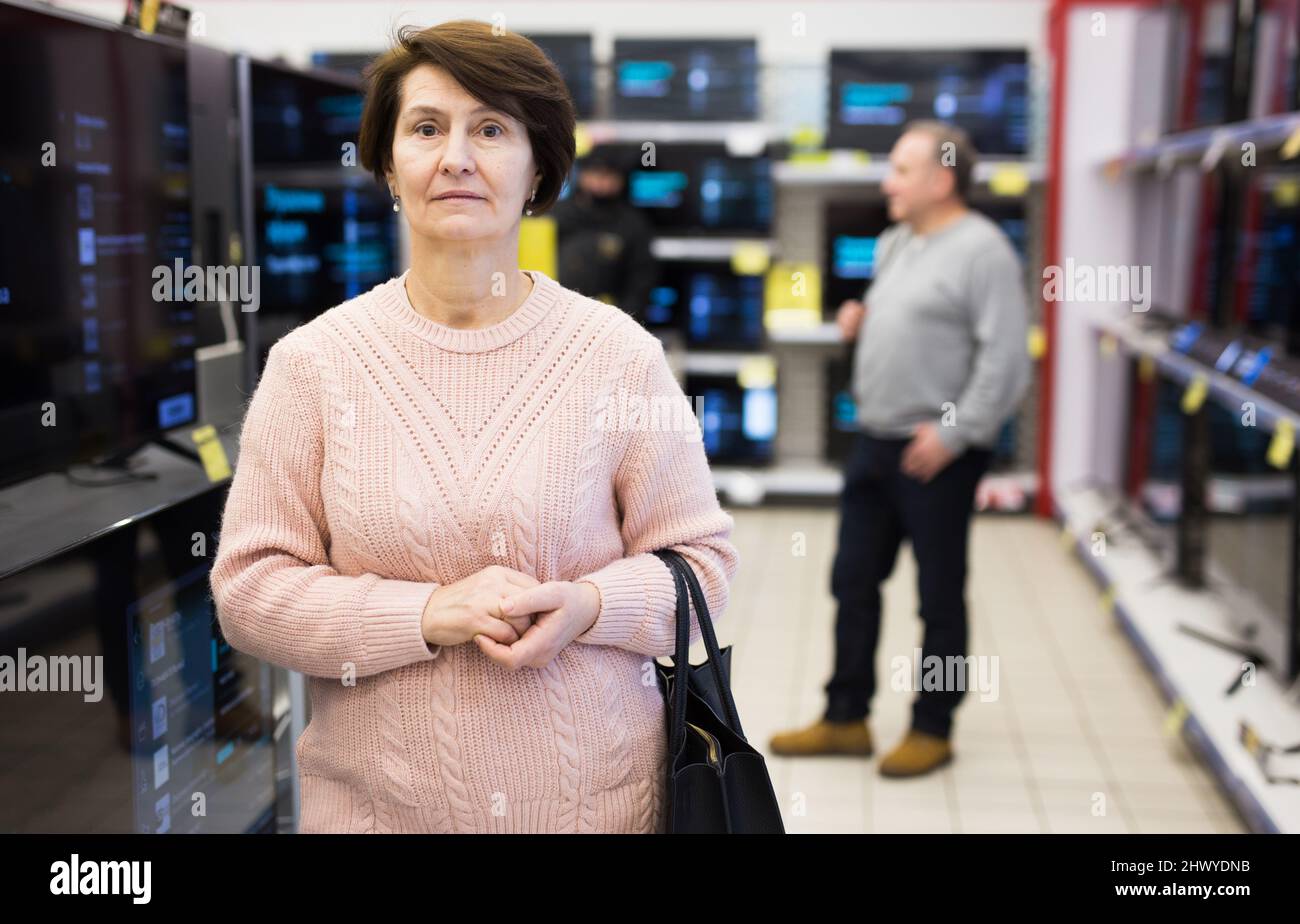 Mature woman in televisions department of appliance store Stock Photo