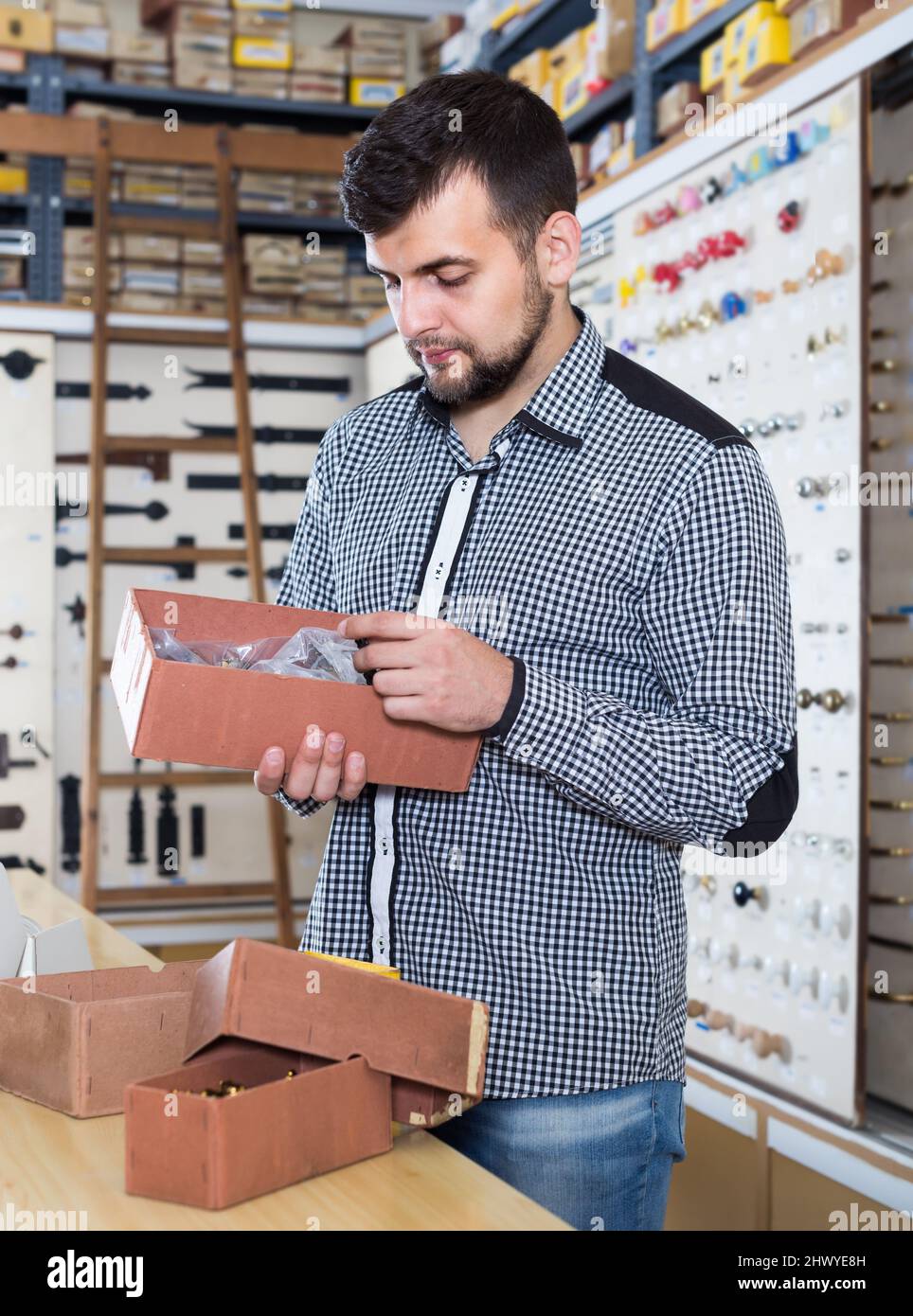 Young seller checking boxes with door handles Stock Photo - Alamy