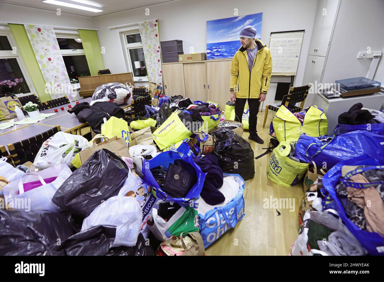 On Sunday, a lot of clothes and supplies were donated in Motala, Sweden, to be driven to Poland towards the Ukrainian border. Poland is one of many countries where Ukrainian refugees are expected after Russia's invasion earlier this week. In the picture: Taras Kuzmenko (yellow jacket), the initiator of the fundraiser, will try to bring as much as he can to help people at the Ukrainian border. Stock Photo