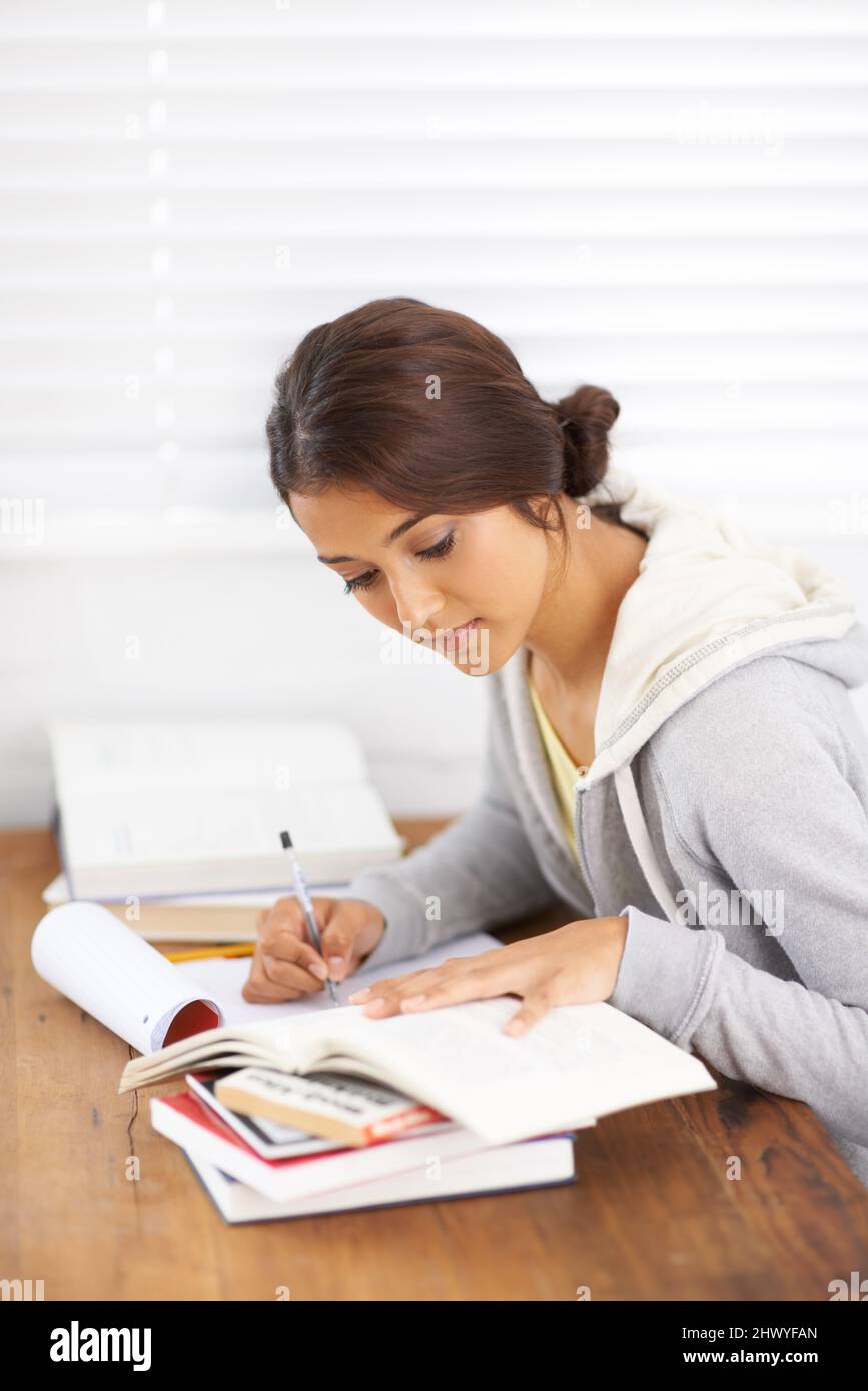 Taking down spark notes. Side view of a young college student taking