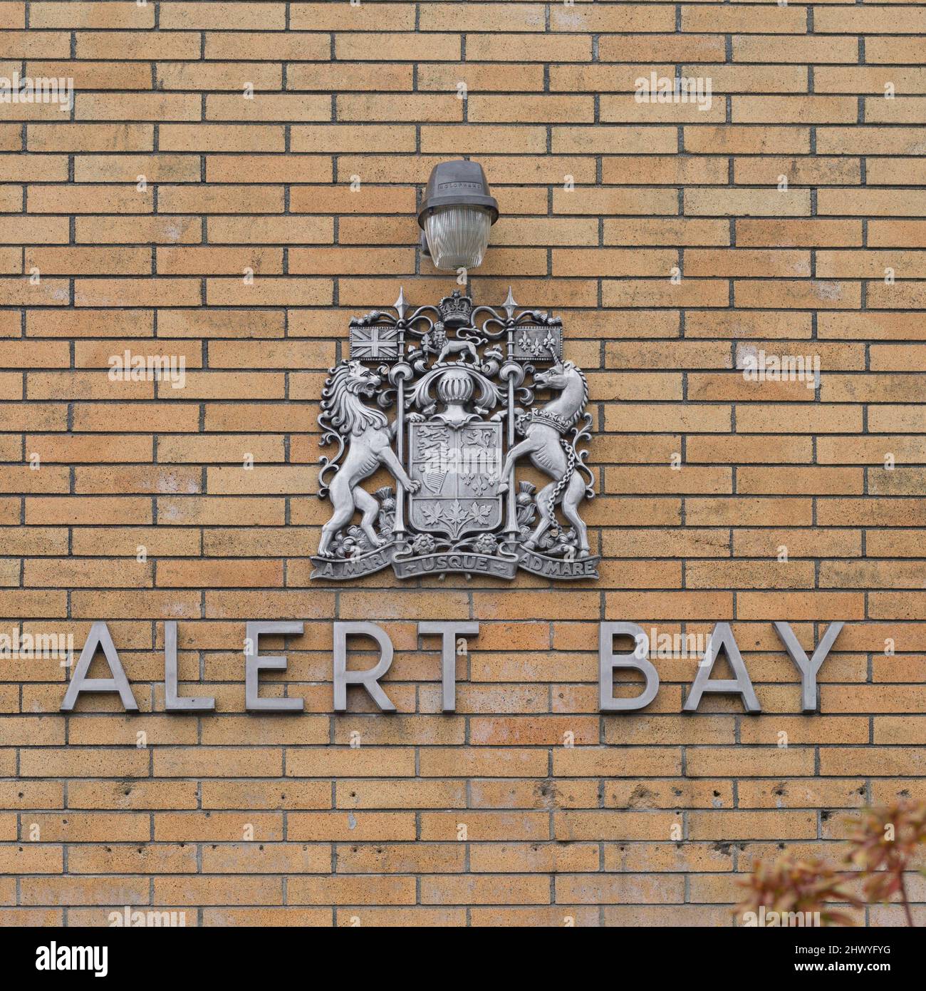 Alert Bay emblem and sign on a brick wall in Cormorant Island, British Columbia, Canada Stock Photo