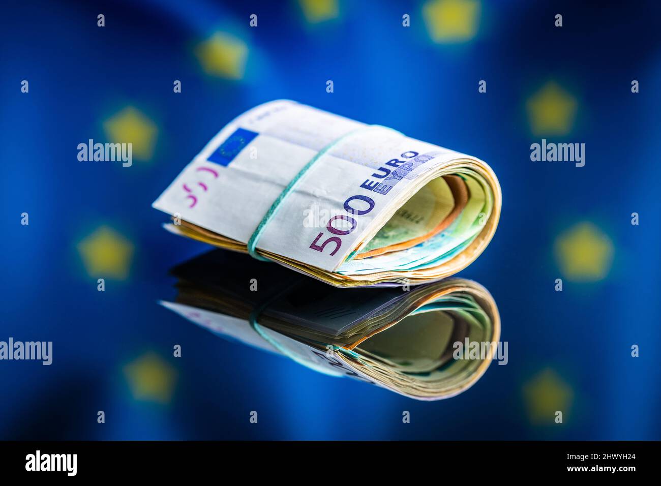 Euro banknotes in front of Europe union flag. The paper European currency. Stock Photo