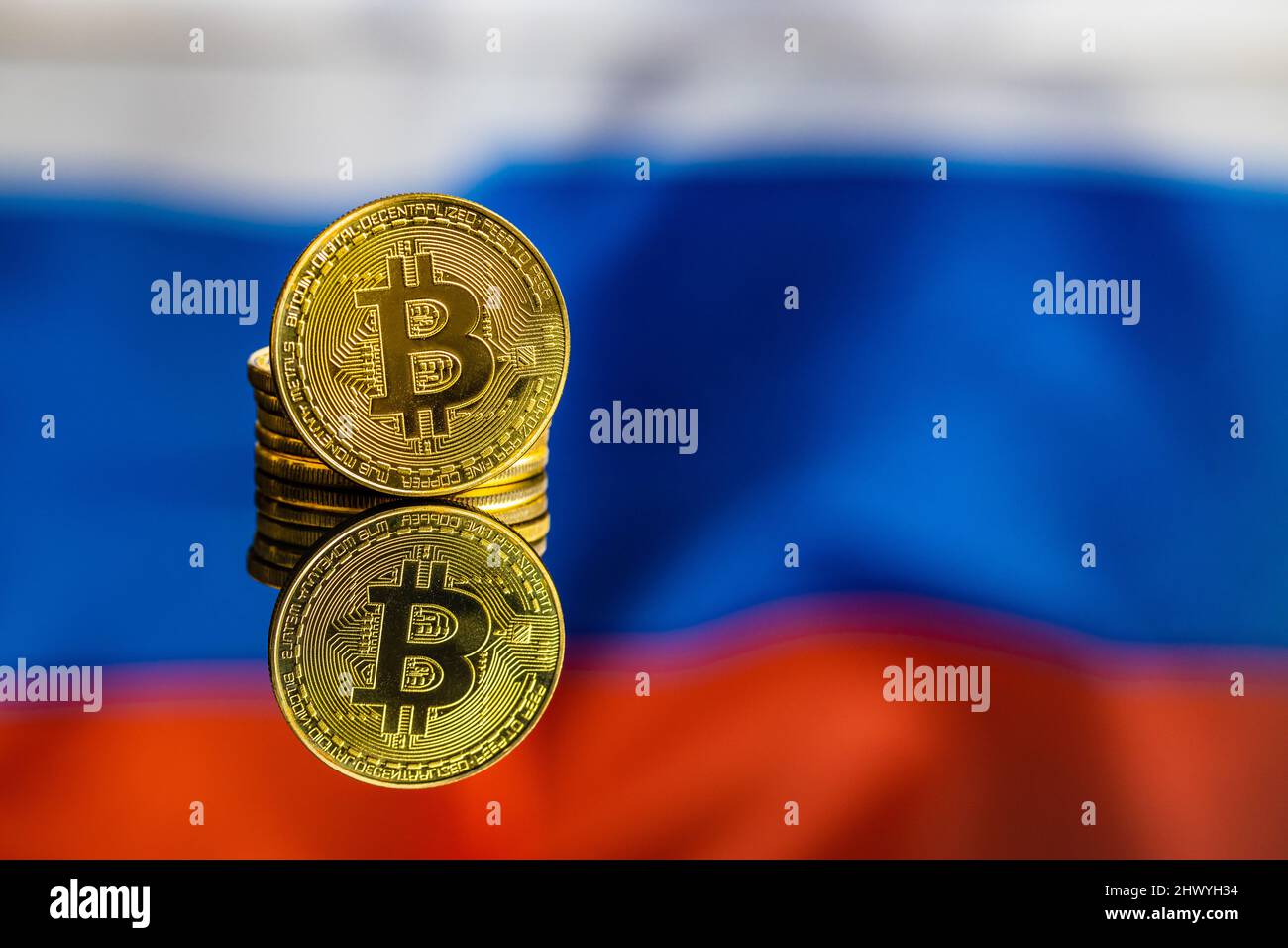 Bitcoin in front of russian flag. Digital cryptocurrency. The russian flag background. Stock Photo