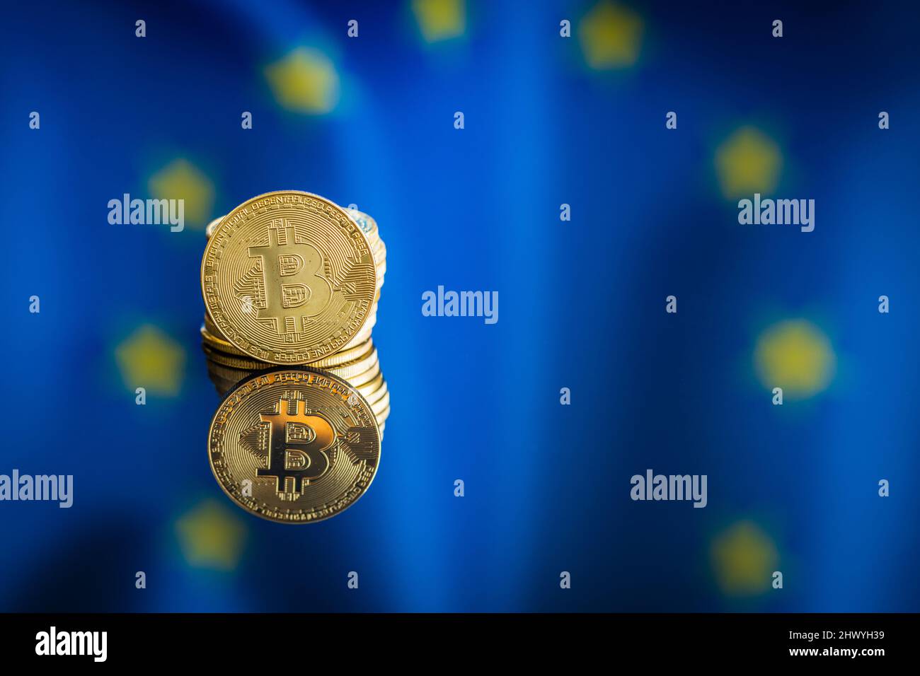 Bitcoin in front of Europe union flag. Digital cryptocurrency. Eu flag background. Stock Photo