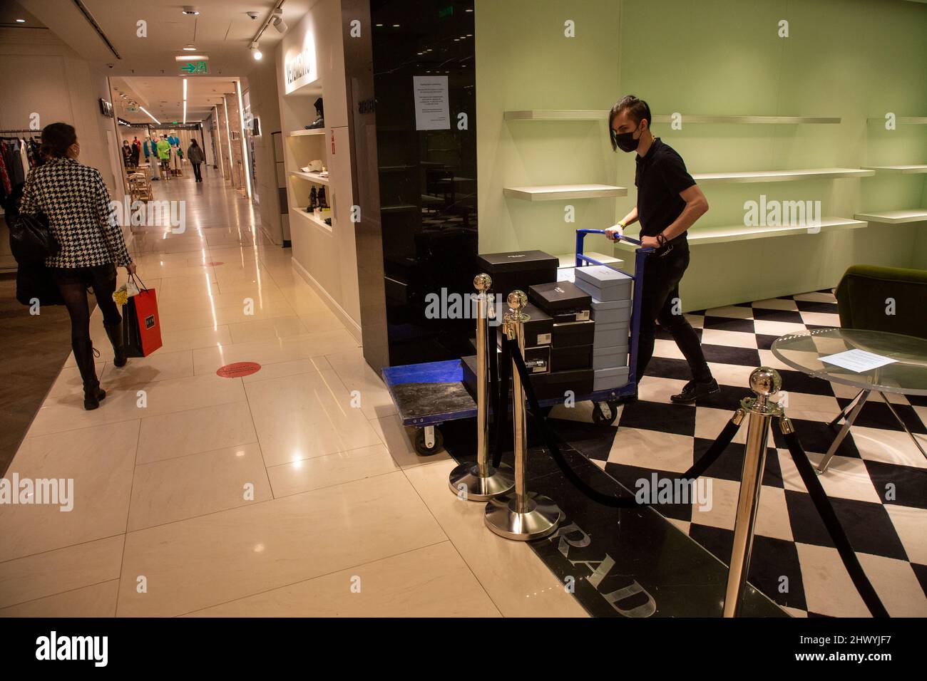 Moscow, Russia. 8th of March, 2022 A store employee takes out the remains  of the Prado products from closed Prado shop at the TsUM Department Store  in central Moscow. Stores of the