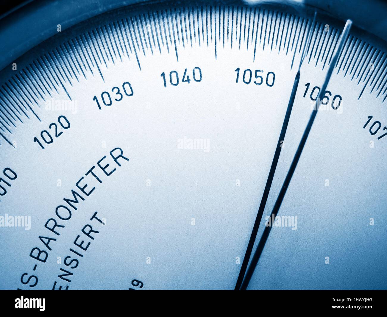 Close-up view of the scale with pointer of an analogue barometer blue toned. Stock Photo