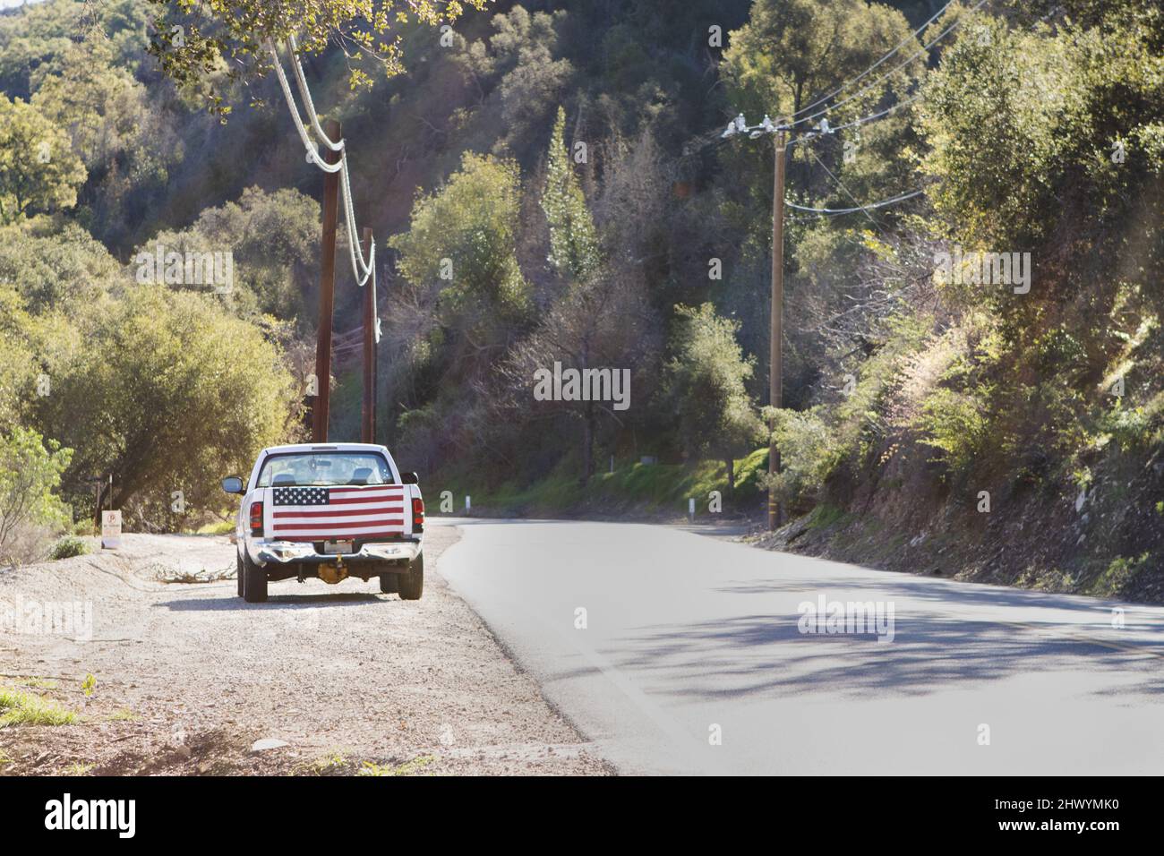 truck on shoulder of the road with US flag on tailgate Stock Photo