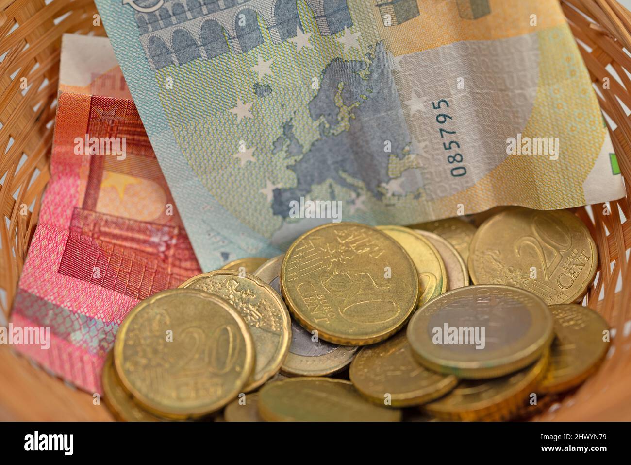 Money in a donation basket Stock Photo