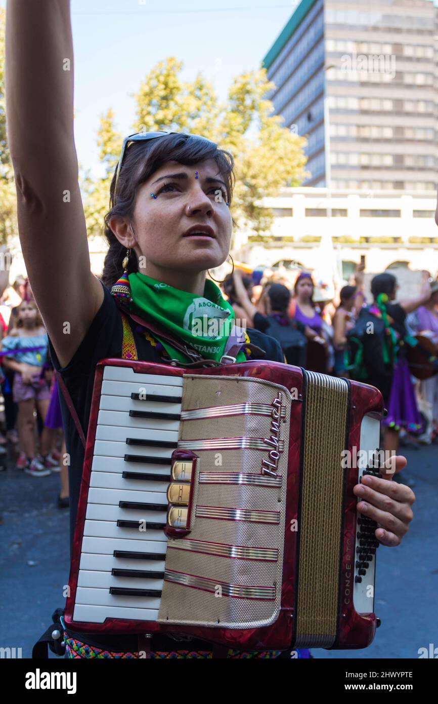 Musician woman with an accordion raising her fist at International
