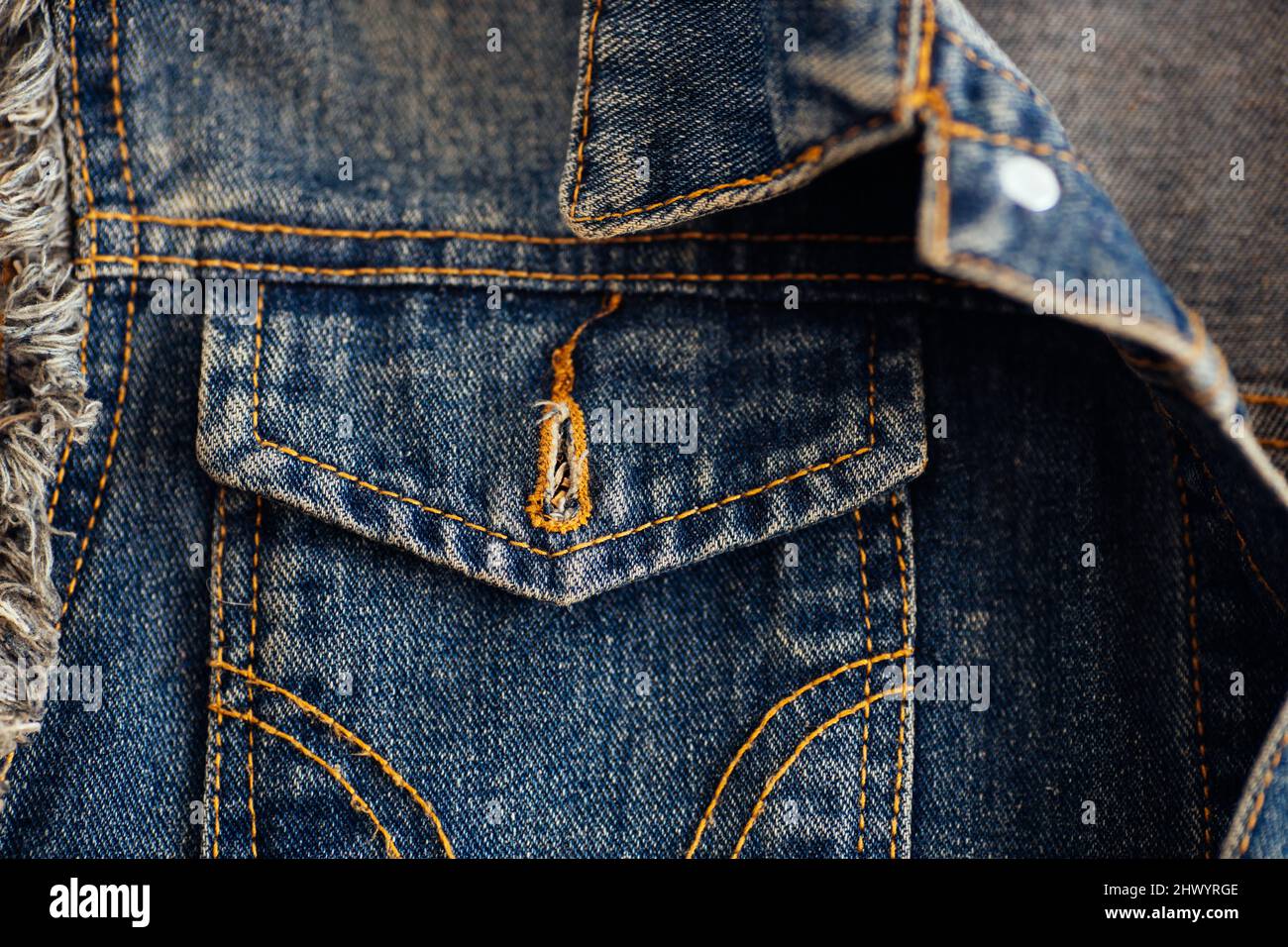 Dark-colored denim jacket pocket close-up. Denim with stitching and seam. Background. Stock Photo