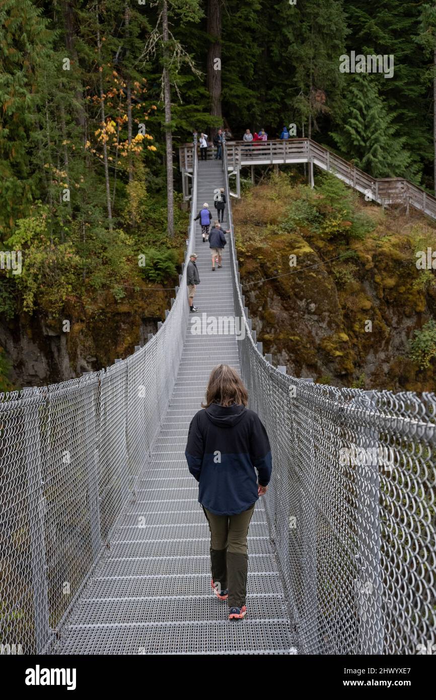 Tourists walking on the Elk Falls Suspension Bridge, Elk Falls Provincial Park, Campbell River, Vancouver Island, British Columbia, Canada Stock Photo