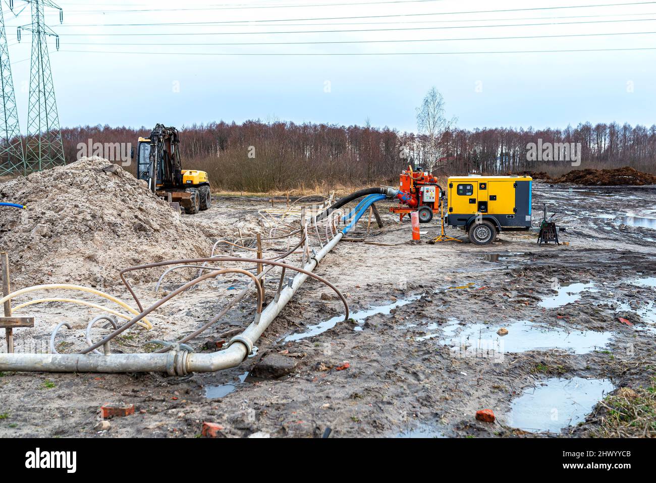 Wellpoint installation to get rid of high groundwater, visible metal and plastic pipes and a large water pump. Stock Photo