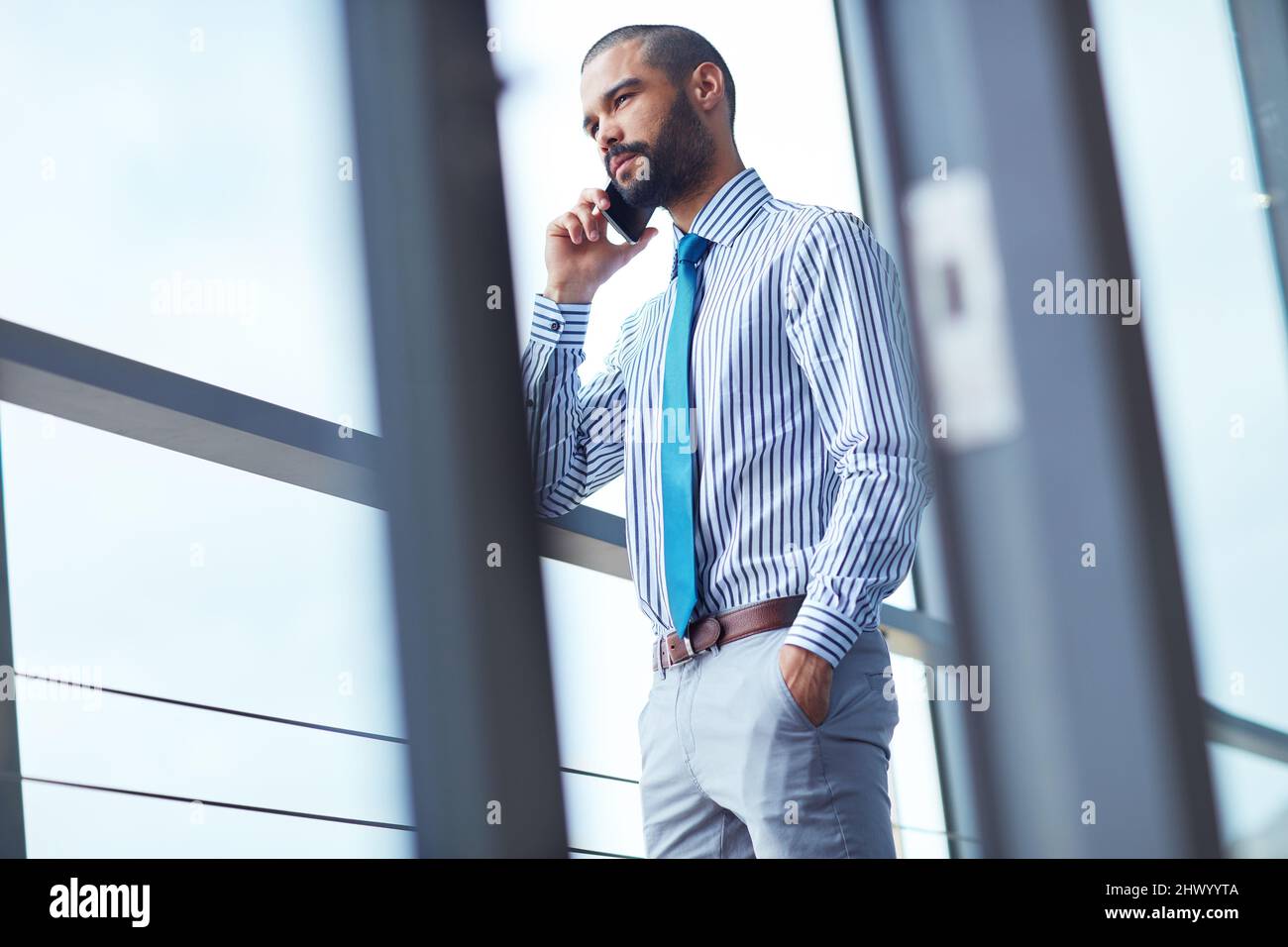 Connecting with a client. Shot of a young businessman talking on a phone at the office. Stock Photo
