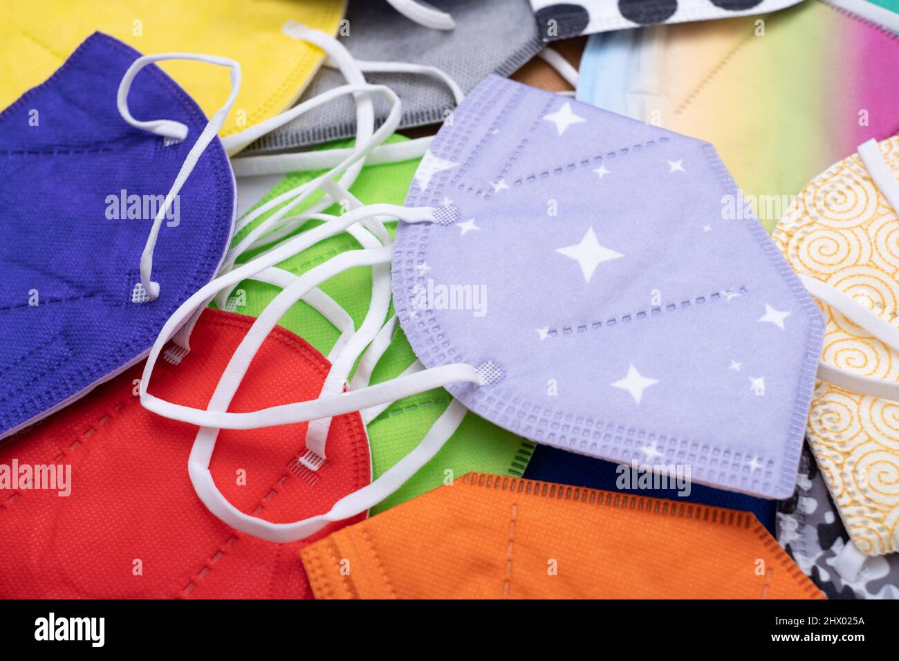 Heap of; different various colors face masks respirators. Top view flat layer. Protection from covid virus during pandemic. Stock Photo