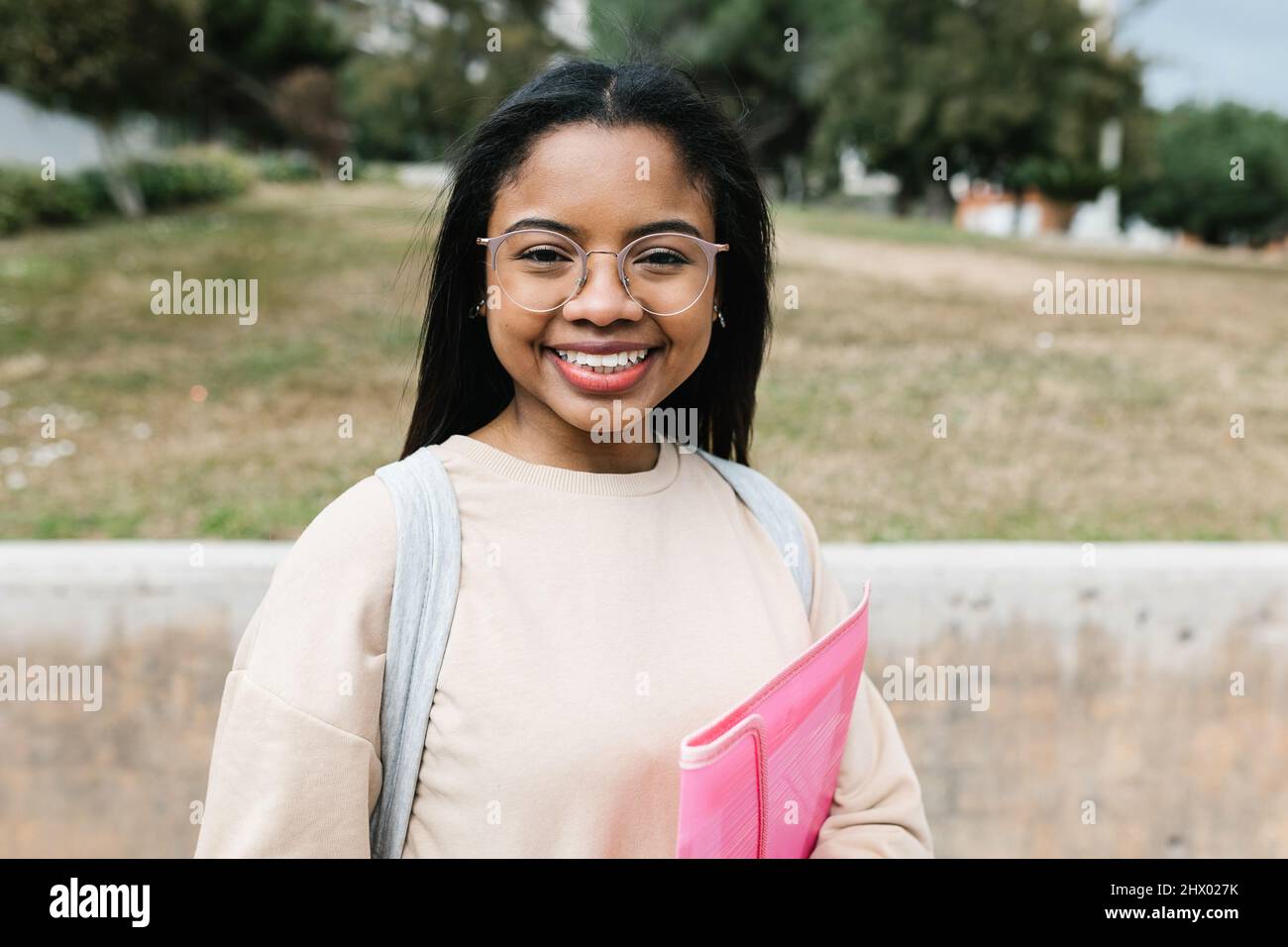 Portrait of smiling young hispanic latina student at campus school university Stock Photo