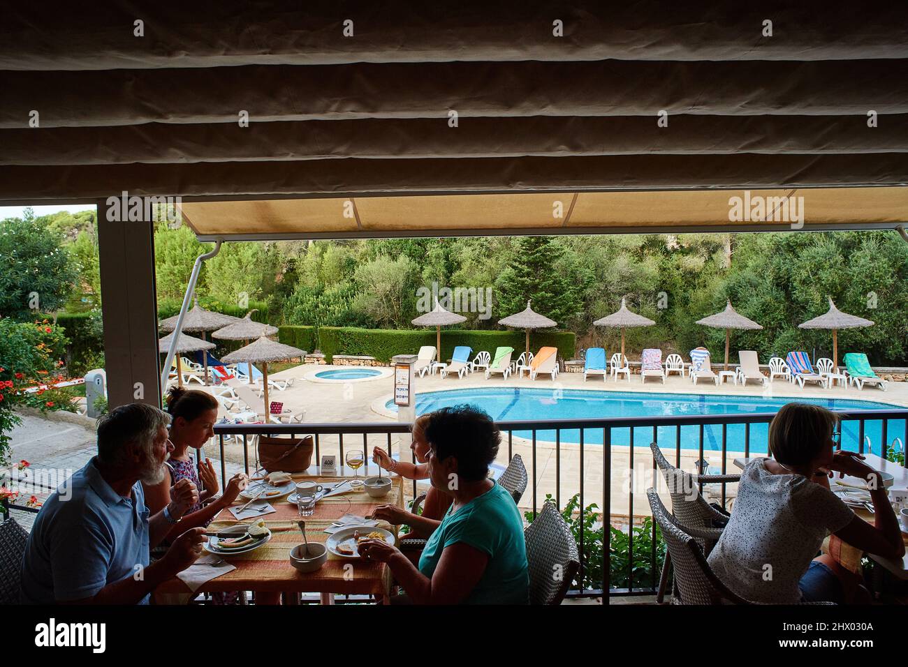 Mallorca, Spain, August 2017: tourists having breakfast at hotel terrace. On the background, around the swimming pool, some german tourists have sprea Stock Photo