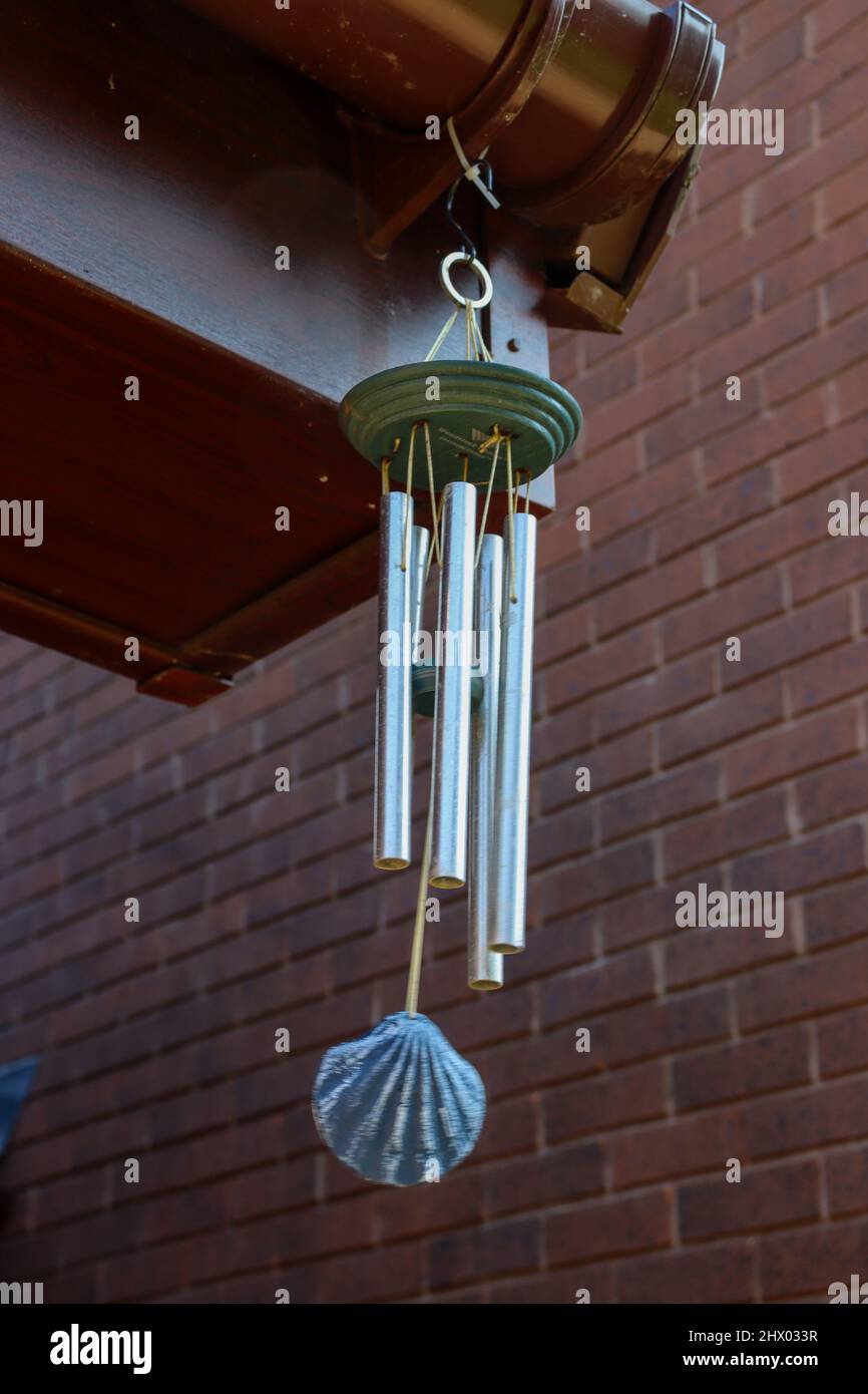 Metal windchime with shell, handing and blowing in the wind Stock Photo