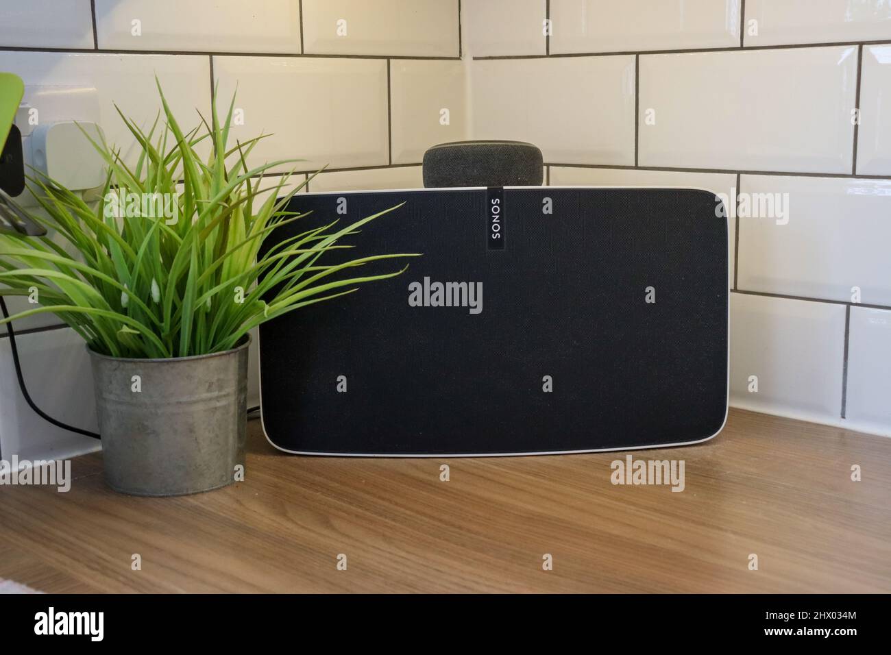 White Sonos Play 5 in a kitchen with an Amazon Alexa Dot on top Stock Photo