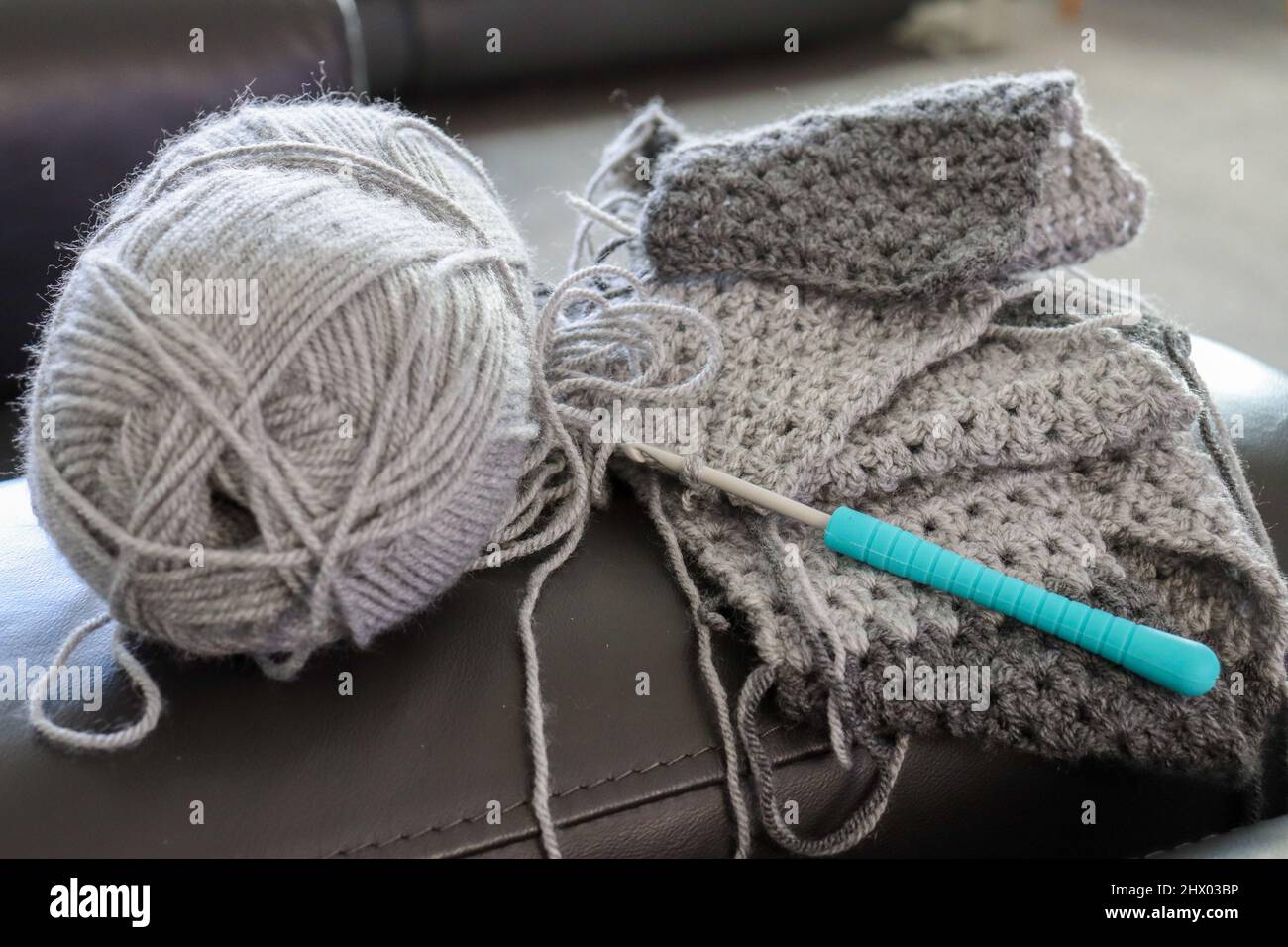 Ball of grey wool and crocheted garment with crochet hook Stock Photo