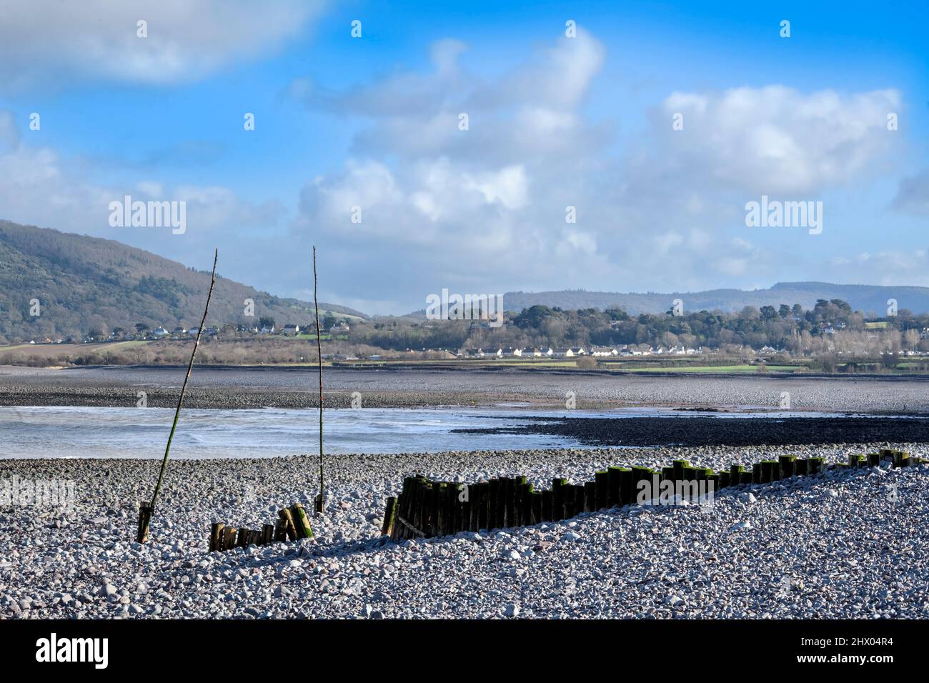 A groyne and harbour entrance marker poles at Porlock Weir, Somerset, UK. Stock Photo