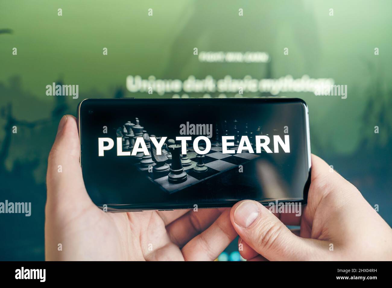 Russia Moscow 25.12.2021 Play to earn logo in mobile phone. Concept for  blockchain nft ethereum cryptocurrency strategy crypto games. Man playing  for Stock Photo - Alamy