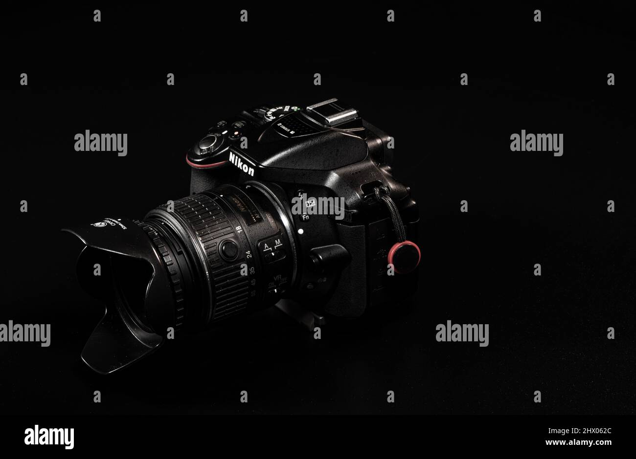 A camera from Nikon with lens in front of a black background on the