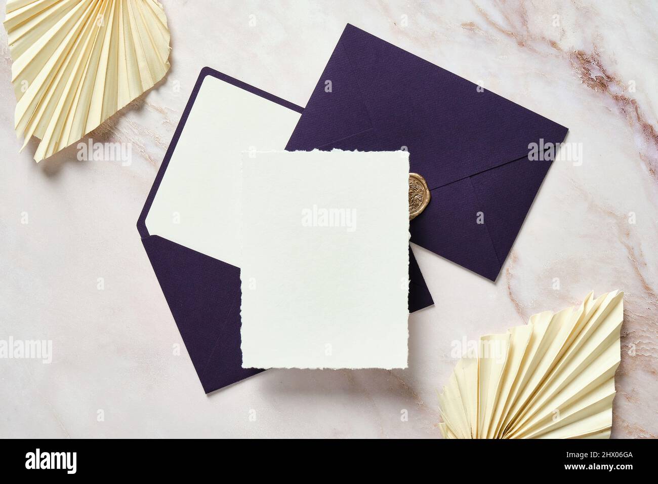 Blank paper card mockup, purple envelopes, dried flowers on stone table