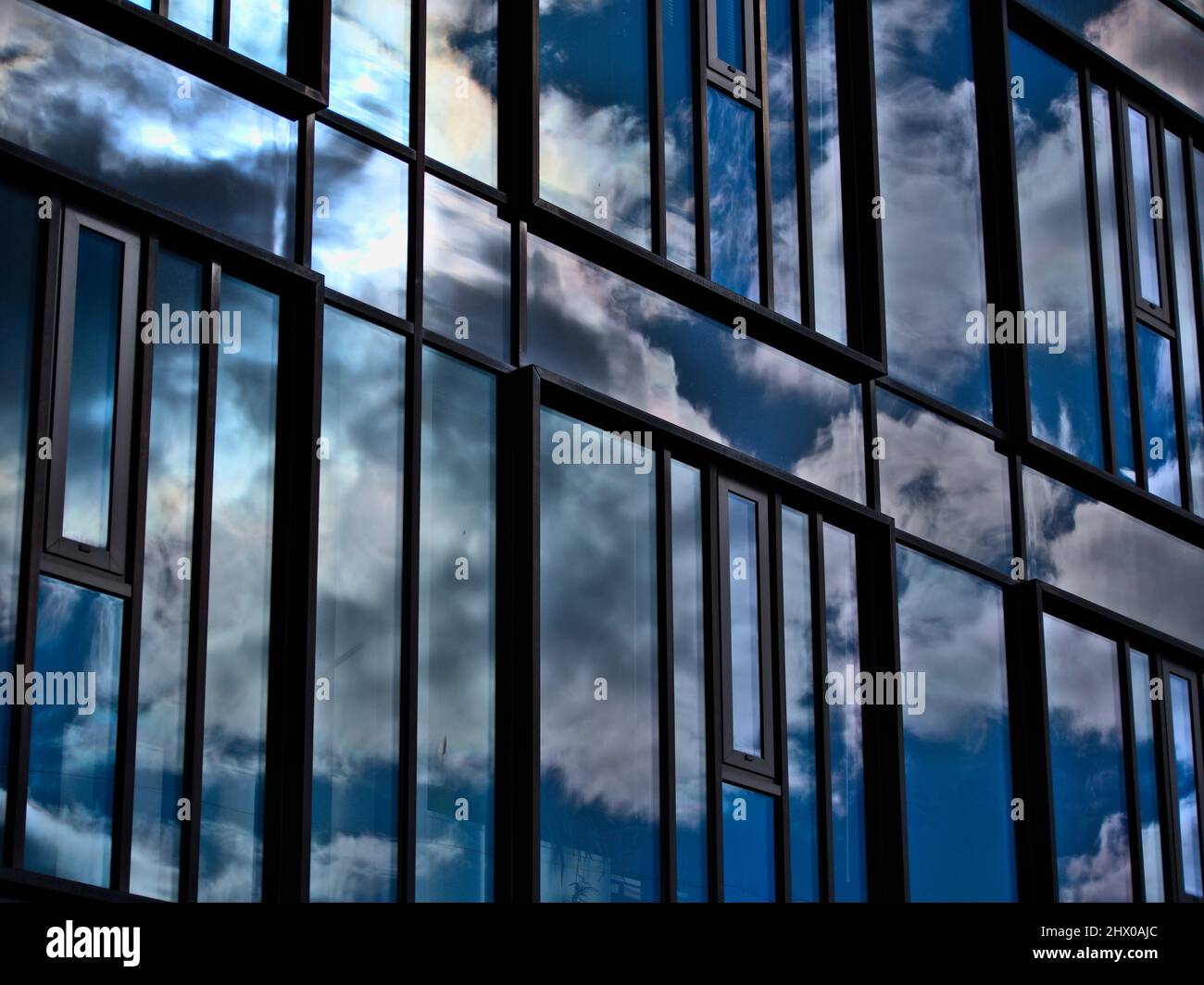 Reflection of blue sky in office building facade Stock Photo - Alamy