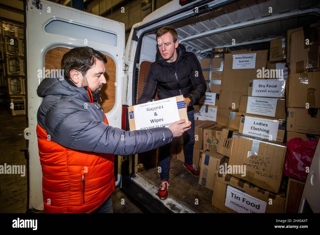 Paul Doherty (left), founder of Woodstock in west Belfast and SDLP MLA Justin McNully offloading donations given by people from Co. Armagh, at global transport and logistics company, DSV, in Belfast that will be packaged and shipped to go to the people of Ukraine. Picture date: Tuesday March 8, 2022. Stock Photo