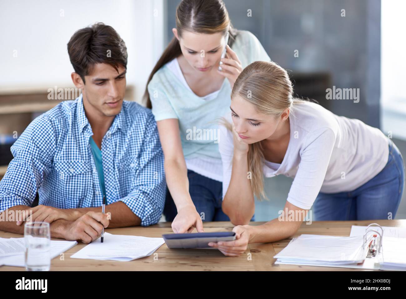 Working together to meet your design needs. Young editors working together on a project. Stock Photo