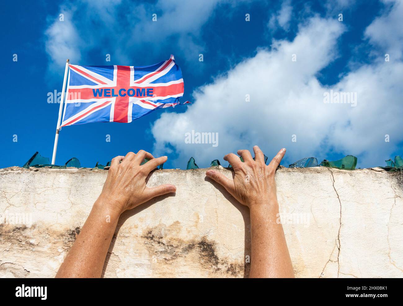 Woman with hands on broken glass on high wall with UK welcome flag. UK immigration, visa policy, Ukraine, Russia conflict refugee, Brexit, EU border Stock Photo