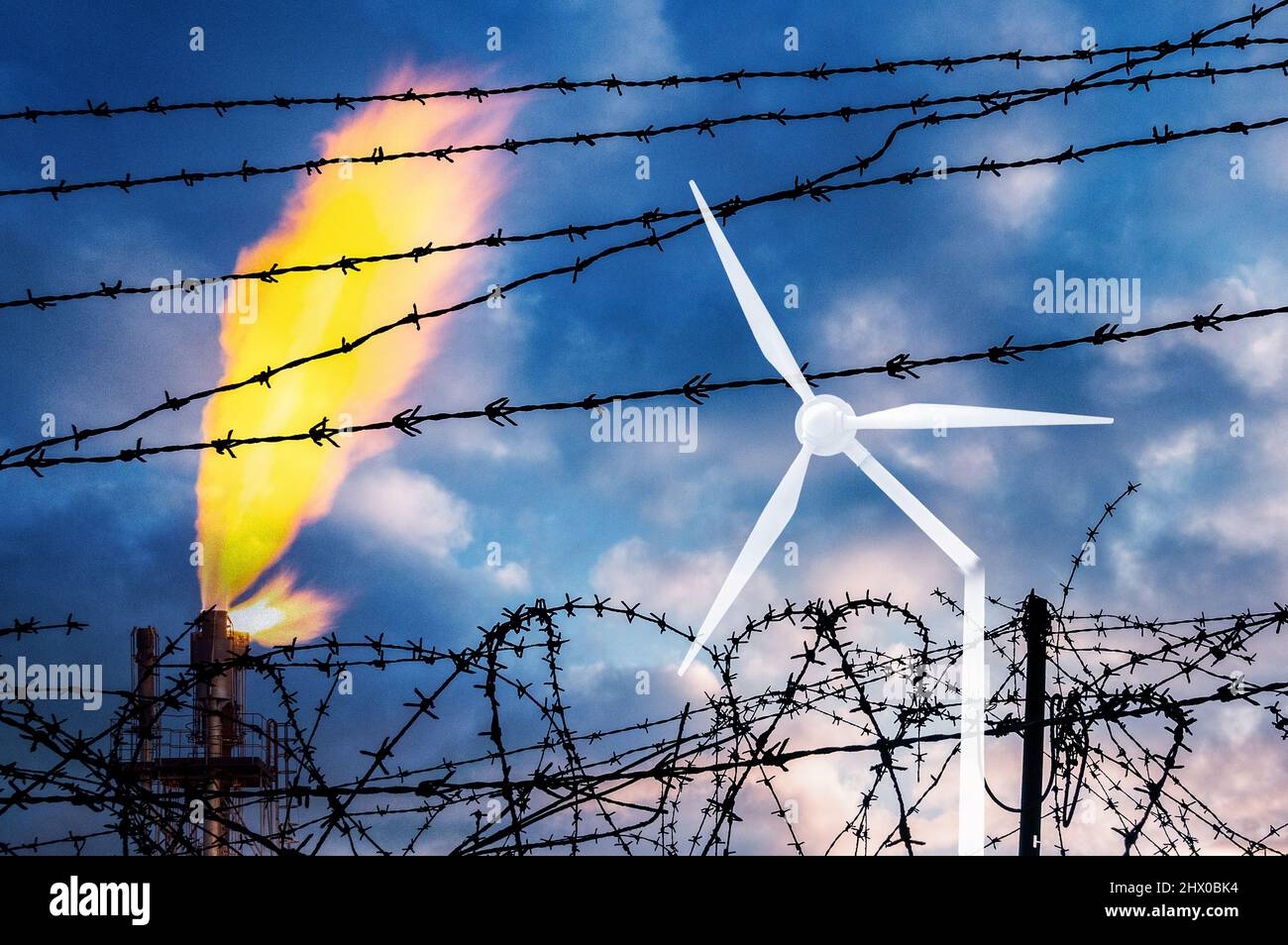 Industrial gas plant behind barbed wire fence with broken wind turbine. Energy crisis, Russia, Ukraine conflict, cop 26, war, renewables, fossil fuel Stock Photo