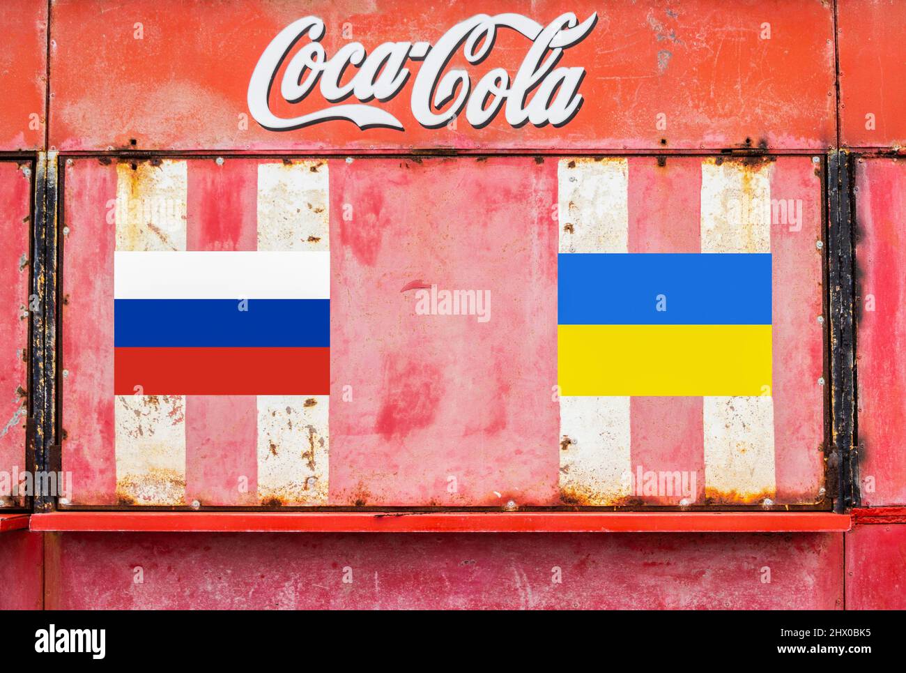 Flags of Russia and Ukraine under Coca Cola logo. Russian sanctions, Russia, Ukraine conflict, war concept... Stock Photo