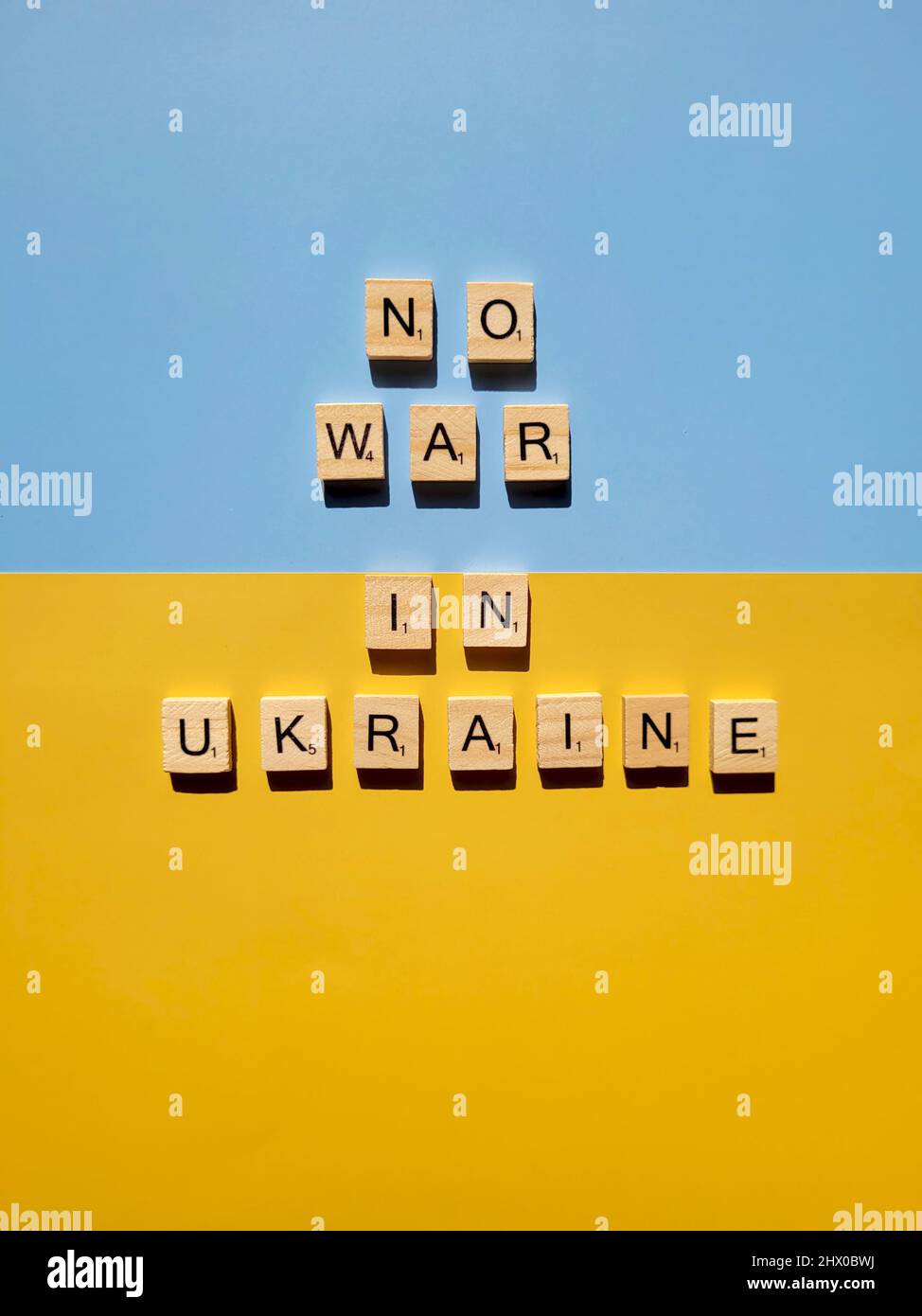 Words on wooden alphabet letters on yellow, blue background close up. Flat lay. Concept of Ukraine freedom and support. Protest action. Stop war. Stock Photo
