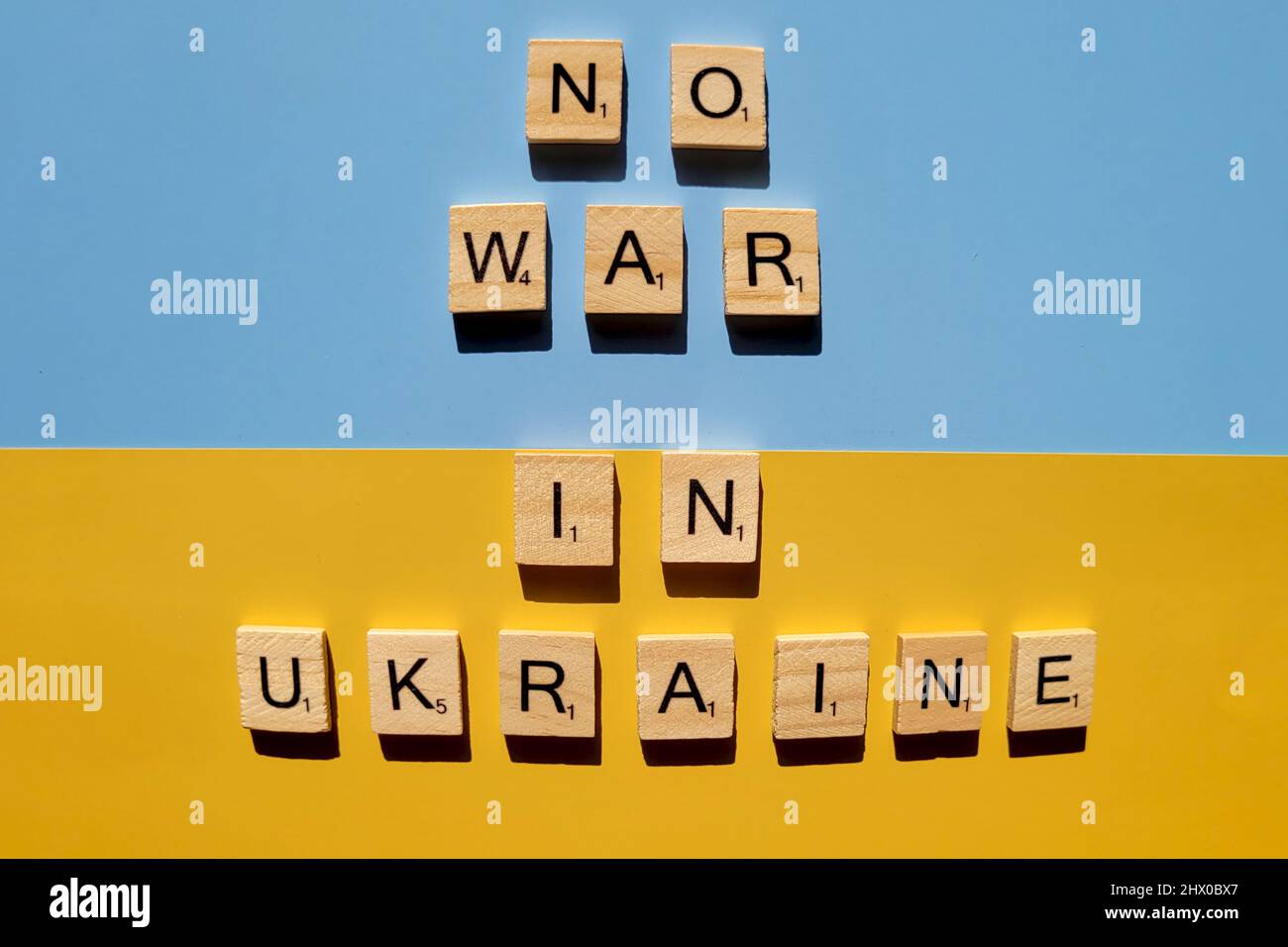 Words on wooden alphabet letters on yellow, blue background close up. Flat lay. Concept of Ukraine freedom and support. Protest action. Stop war. Stock Photo