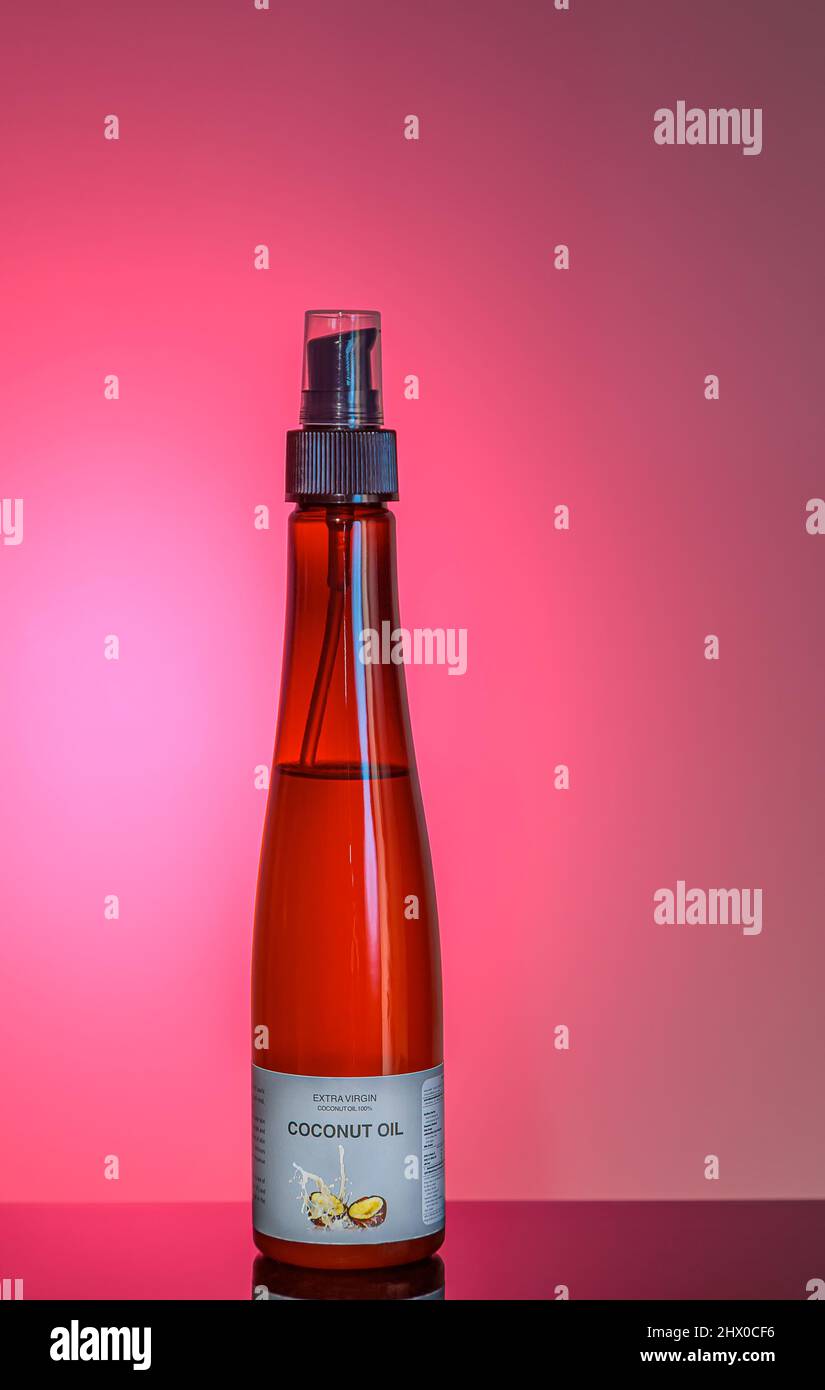 Bottle of coconut oil on a red background. Close-up. Object shooting. Stock Photo